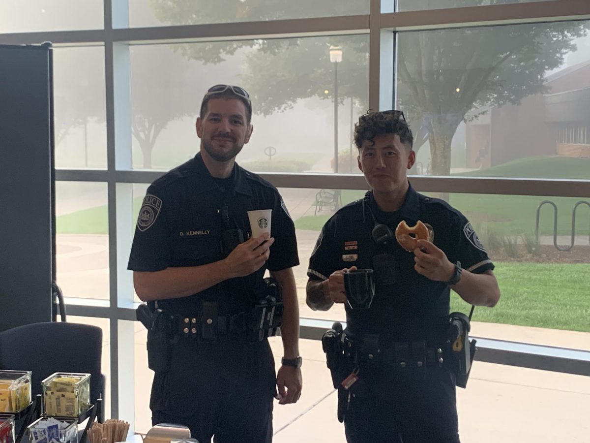 Officers Dustin Kennelly and Phillip Pang share coffee and doughnuts